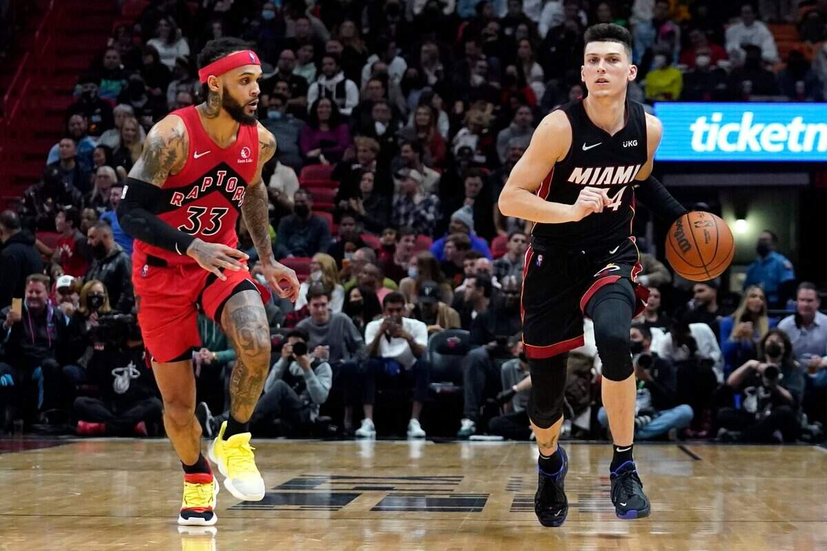 El jugador del Heat Tyler Herro (der.) conduce la pelota ante la marca de Gary Trent Jr. , de los Raptors, en el partido celebrado el 1ro de febrero de 2022 en Toronto.