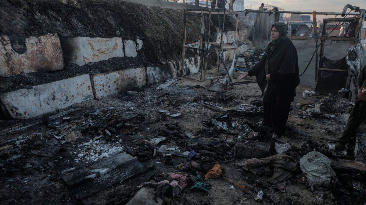 Una mujer palestina camina por una sección de tiendas de campaña que fueron destruidas por un bombardeo israelí, el martes 14 de enero de 2025, en la ciudad de Deir Al Balah, en la región central de la Franja de Gaza.