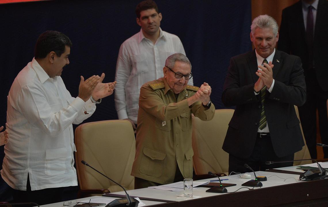 El ex presidente cubano Raúl Castro (centro), quien todavía es primer secretario del Partido Comunista de Cuba, durante la conmemoración de 14to aniversario del acuerdo comercial regional conocido como el ALBA, flanqueado por el presidente venezolano Nicolás Maduro (izq) y el mandatario cubano, Miguel Díaz-Canel (der), en el Palacio de Convenciones de La Habana el 14 de diciembre del 2018.