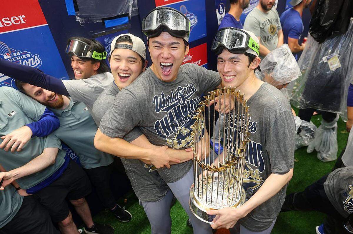 Los lanzadores japoneses Shohei Ohtani (izq.), Yoshinobu Yamamoto (centro) y Roki Sasaki celebran tras ganar con los Dodgers la Serie Mundial ante Toronto.