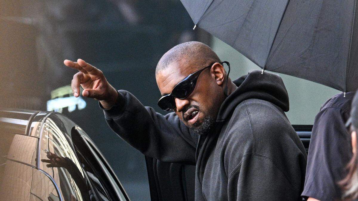 El rapero y productor estadounidense Kanye West saluda tras llegar al Aeropuerto Internacional de Shanghái Pudong el 11 de julio de 2025. Kanye West ofrecerá un concierto en Shanghái el 12 de julio.