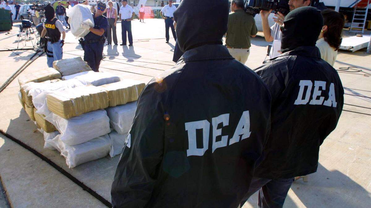 Photo by Hector GAbino - DEA agents over looking the process of the arriving of the 29 bales of Marihuana seized after a high speed chase Sunday morning ended in the interdiction of the drugs and aprehension of three suspects smugglers by U.S. and Bahamian athorities. They arrived to the Coast Guard Station in Miami Beach on Tuesday, August 28.