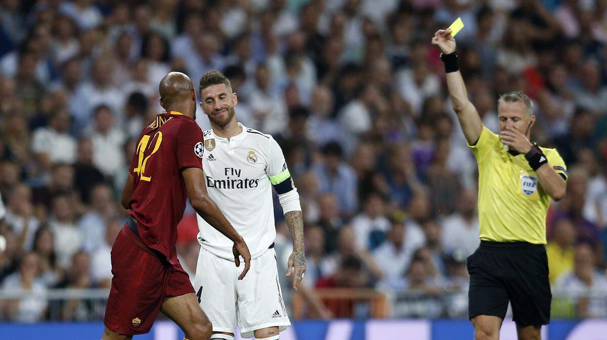 El árbitro Bjorn Kuipers le muestra la tarjeta amarilla al defensa del Real Madrid Sergio Ramos (centro) en el partido ante la Roma, celebrado el 19 de septiembre de 2018 en la Liga de Campeones.