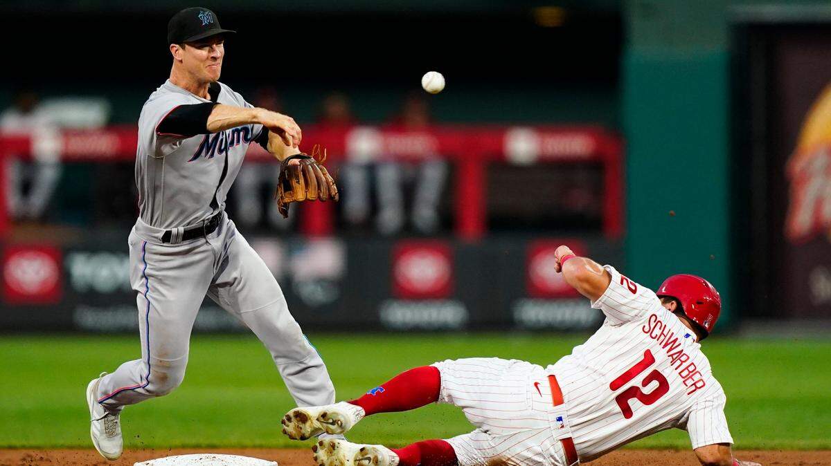 El segunda base de los Marlins Joey Wendle tira a primera en una jugada de doble matanza en el primer inning del partido ante los Filis, celebrado el 9 de agosto de 2022 en Filadelfia.