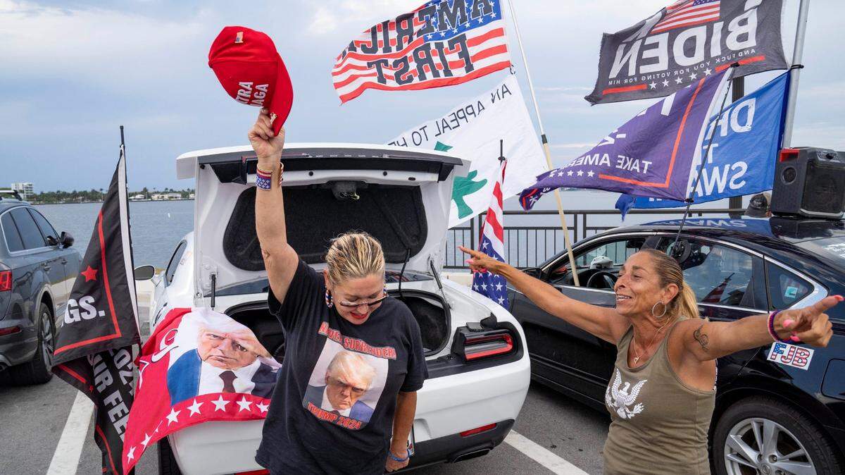 Maria Korynsel (izq.) y Debbie Macchia muestran su apoyo a Donald Trump después de que el expresidente fuera declarado culpable de 34 cargos en su juicio penal por el pago irregular a una actriz porno y la falsificación de registros comerciales para ocultarlo, el 30 de mayo de 2024 en Palm Beach, Florida.