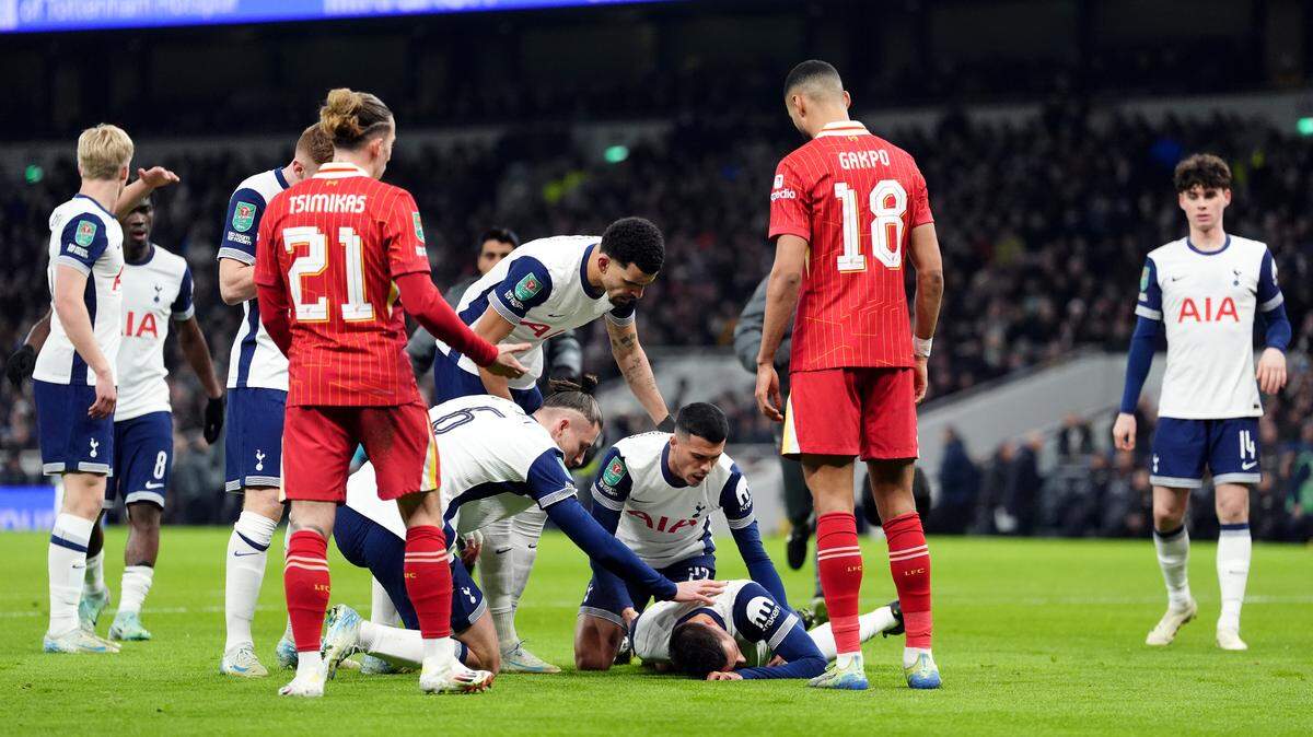 El mediocampista uruguayo del Tottenham Rodrigo Bentancur es asistido por los jugadores de su equipo y el Liverpool, en el partido de ida de la semifinal de la Copa de la Liga inglesa, celebrado el 8 de enero de 2025 en Londres.