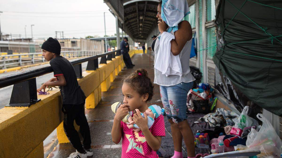 Elsy Hernández junto a sus hijos, Génesis, de 5 años y David de 9, quienes emigraron de Honduras, esperan en la frontera en el lado mexicano a que les den asilo en los EEUU.