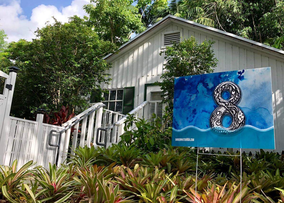 Una casa blanca tiene un póster azul con un número 8 en blanco y negro.
