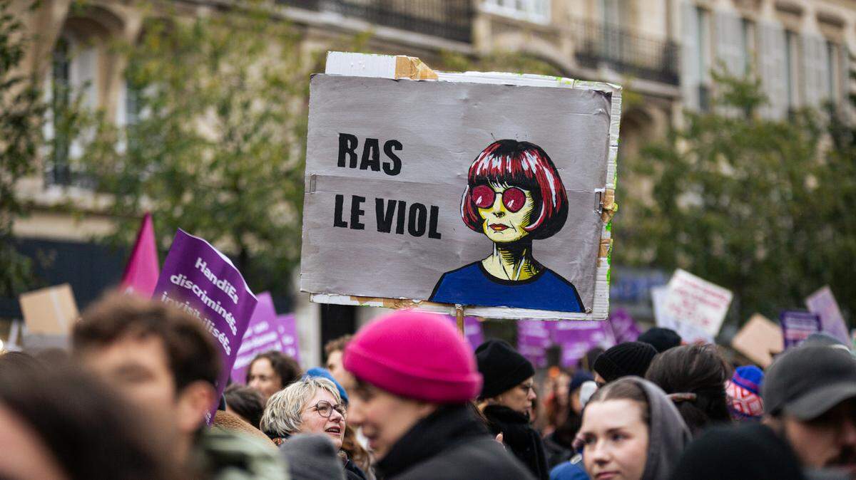Una persona sostiene una pancarta que dice “Estoy harta de las violaciones”, con una ilustración de Gisèle Pelicot, durante una protesta en contra la violencia sexual y de género en París, el sábado 23 de noviembre de 2024. El exposo de Gisèle Pelicot fue acusado de drogarla y violarla junto a decenas de desconocidos por años. 