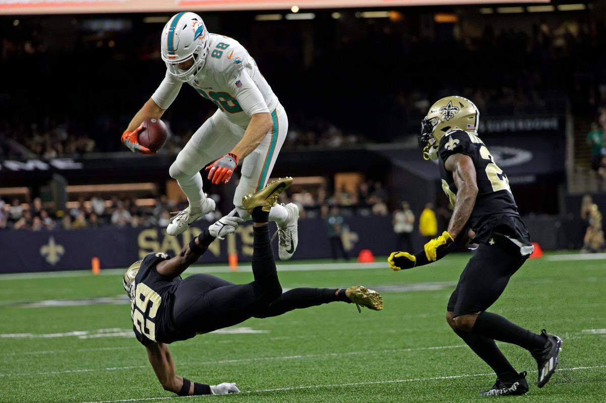 El tight end de los Dolphins Mike Gesicki salta sobre el cornerback de los Saints Paulson Adebo (29), en el partido celebrado el 27 de diciembre de 2021 en New Orleans.