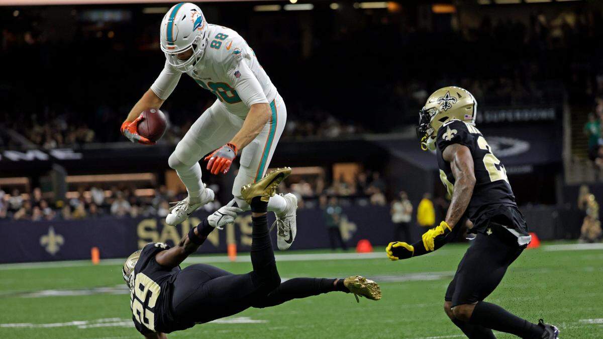 El tight end de los Dolphins Mike Gesicki salta sobre el cornerback de los Saints Paulson Adebo (29), en el partido celebrado el 27 de diciembre de 2021 en New Orleans.