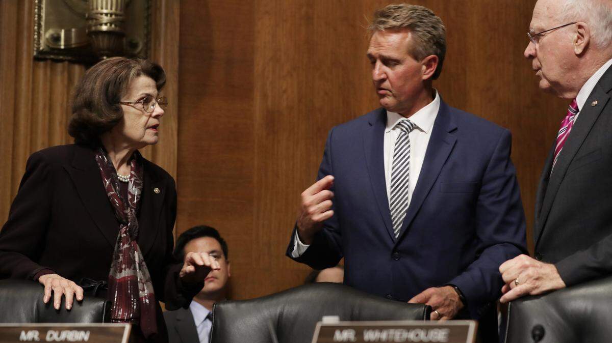 La senadora Dianne Feinstein (izq.), la demócrata de más rango en la Comisión Judicial del Senado, y el senador Patrick Leahy (derecha), demócrata por Vermont, negocian con el senador Jeff Flake, republicano por Arizona (centro) la propuesta de Flake de demorar el voto de confirmación del juez Judge Brett Kavanaugh a la Corte Suprema durante una audiencia en el Capitolio este viernes.