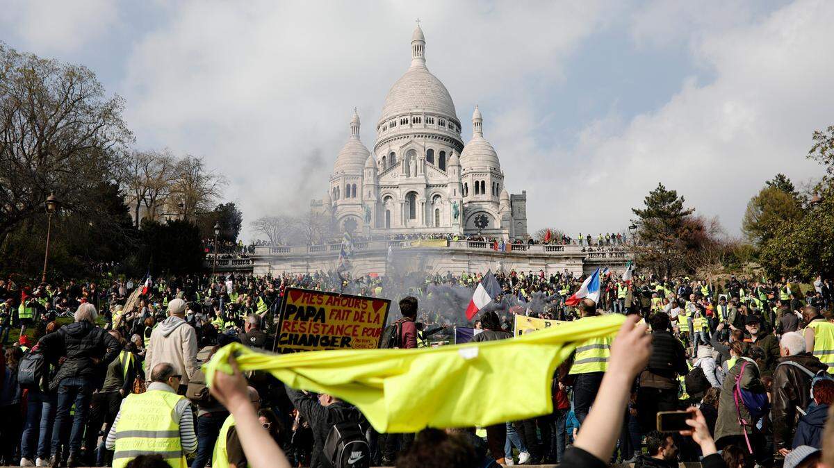 Los manifestantes participan en un mitin en la Basílica de Sacre Coeur en Montmartre, París, sábado, 23 de marzo de 2019. El gobierno francés prometió fortalecer la seguridad mientras los manifestantes de chalecos amarillos organizan una 19a ronda de manifestaciones, en un esfuerzo por evitar una repetición de la última. Los disturbios de la semana en París.