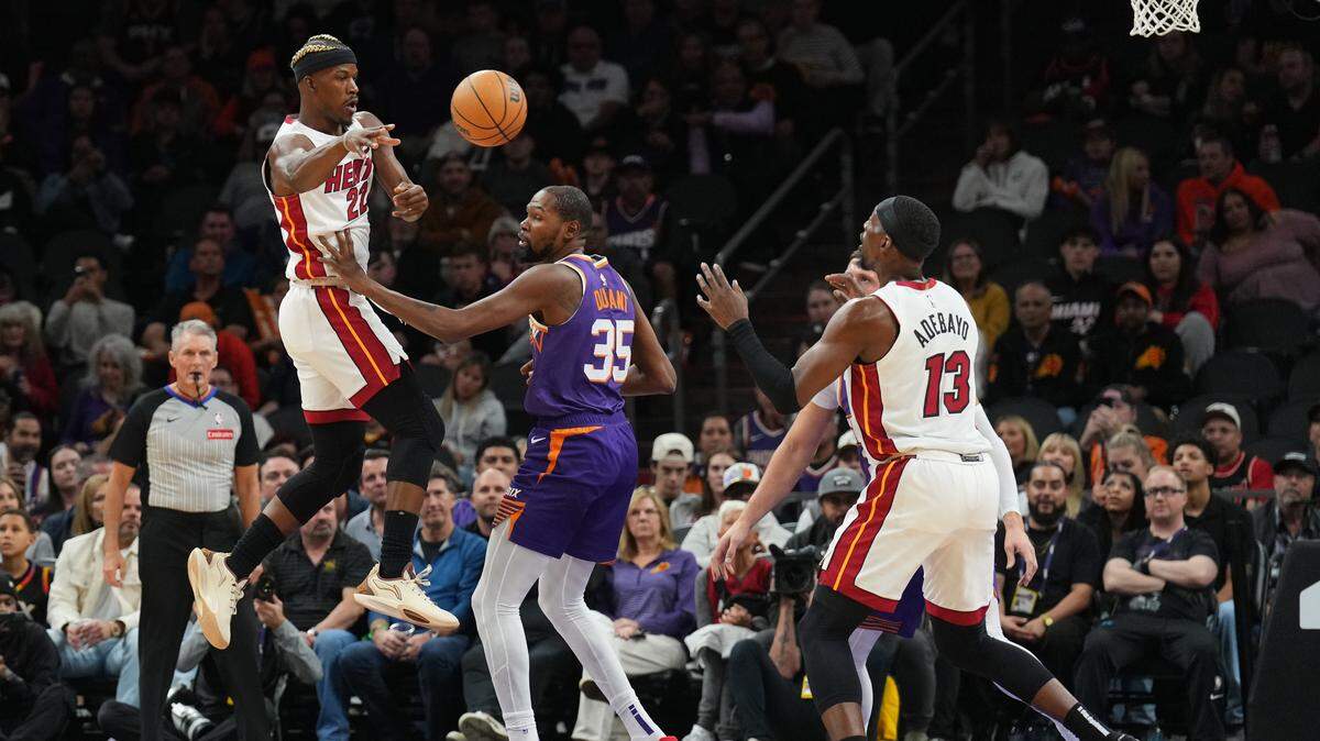 El jugador del Heat de Miami Jimmy Butler (izq.) pasa la pelota a Bam Adebayo ante la marca de Kevin Durant, de los Suns, en el partido de la NBA celebrado el 6 de noviembre de 2024 en Phoenix.