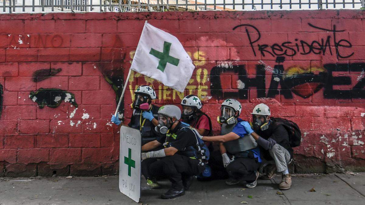 Personal médico busca refugio durante enfrentamientos entre activistas de la oposición y la Guardia Nacional en Caracas el 3 de junio de 2017.