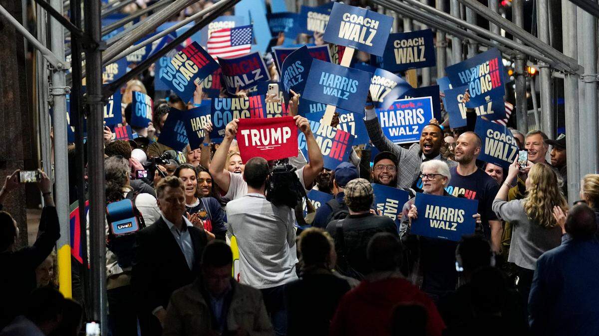 Un simpatizante del expresidente Donald Trump muestra su pancarta ante decenas de seguidores de la vicepresidenta Kamala Harris, antes del debate de los candidatos a la vicepresidencia el martes 1 de octubre de 2024, en Nueva York.