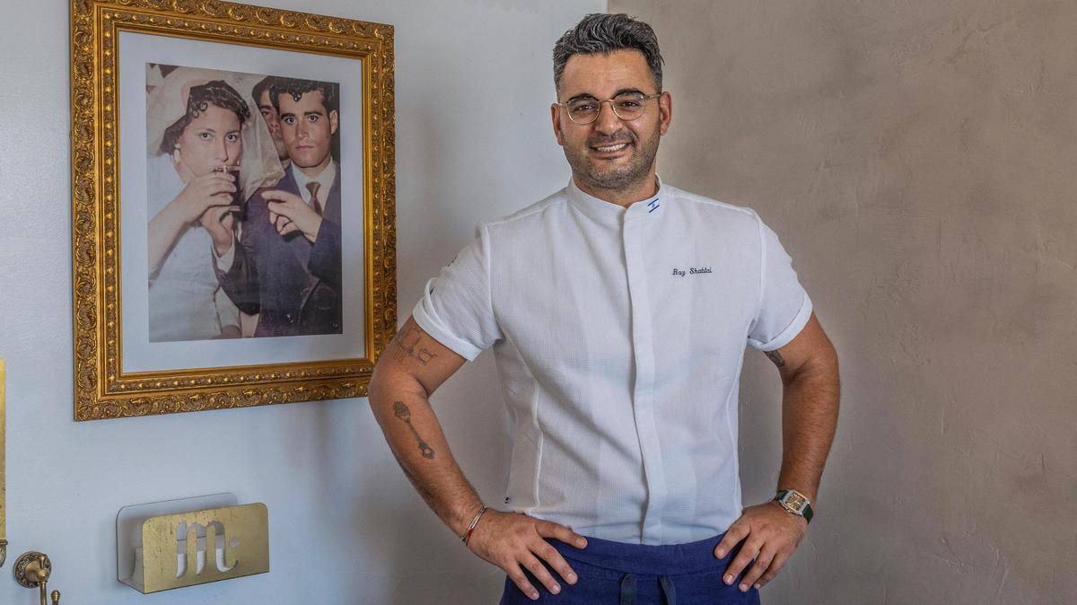 El chef y propietario Raz Shabtai junto a un retrato de sus abuelos Mutra y Roje, que cuelga en su nuevo restaurante israelí kosher, Mutra, en North Miami. Shabtai afirma que su abuela fue su mayor inspiración para convertirse en chef.