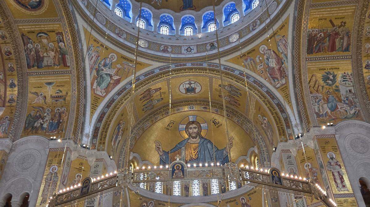 Cripta de la Iglesia de San Sava en Belgrado, uno de los templos ortodoxos más grandes del mundo, decorada con mosaicos dorados, columnas de mármol y grandes candelabros.