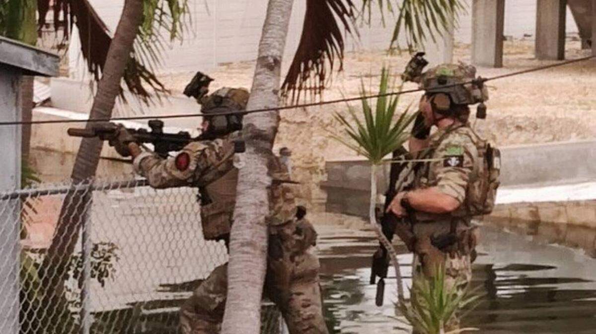 Agentes del FBI, equipados de chalecos antibalas y portando fusiles semiautomáticos, realizan una redada en una casa de los Cayos de la Florida, el viernes 16 de diciembre de 2022.
