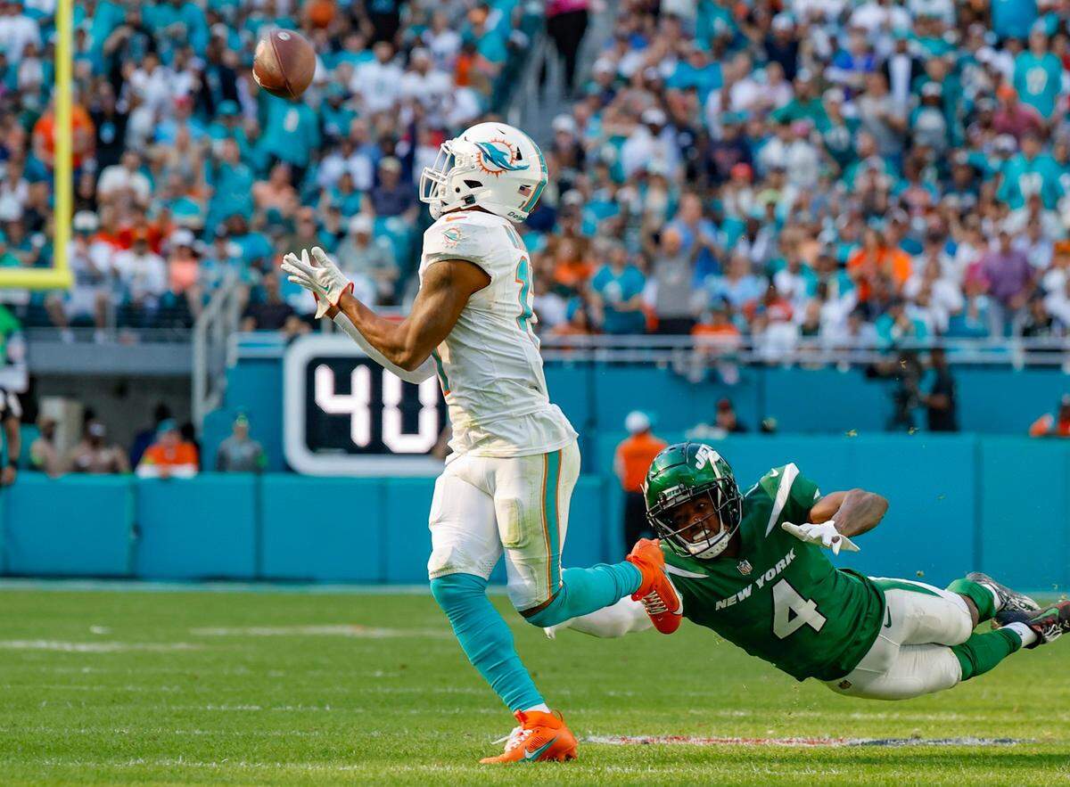 El wide receiver de los Dolphins Jaylen Waddle atrapa un pase ante la marca del cornerback de los Jets de New York D.J. Reed, en el partido efectuado el 17 de diciembre de 2023 en el Hard Rock Stadium en Miami Gardens, Florida.
