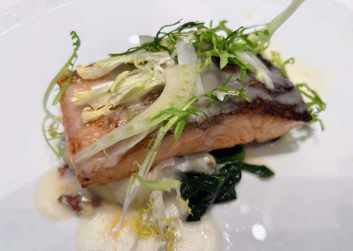 Plato de salmón en Celebrity Grand Cuvée que ejemplifica la calidad de la comida en Celebrity Silhouette.