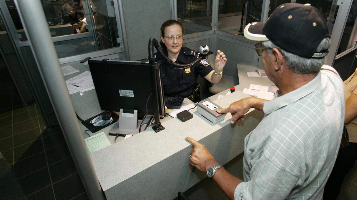 Foto de archivo de una oficial del Servicio de Aduanas y Protección Fronteriza (CBP) verificando datos de un viajero antes de su entrada a Estados Unidos.