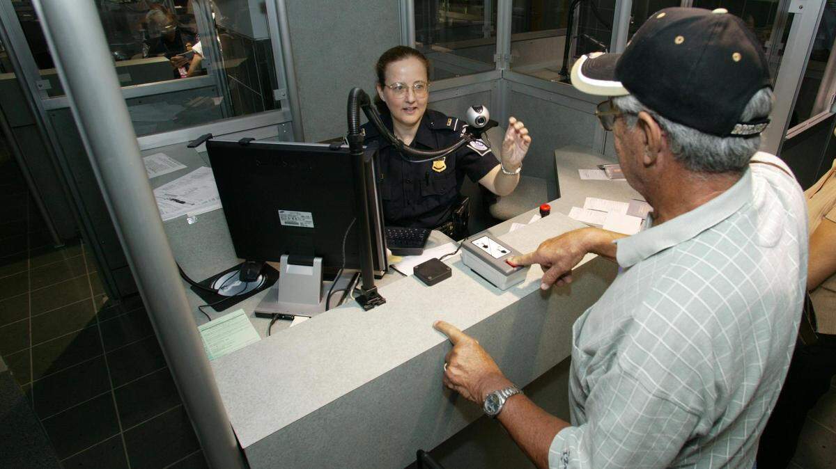 Foto de archivo de una oficial de Aduanas y Protección Fronteriza (CBP) verificando datos de un viajero a su ingreso en Estados Unidos.