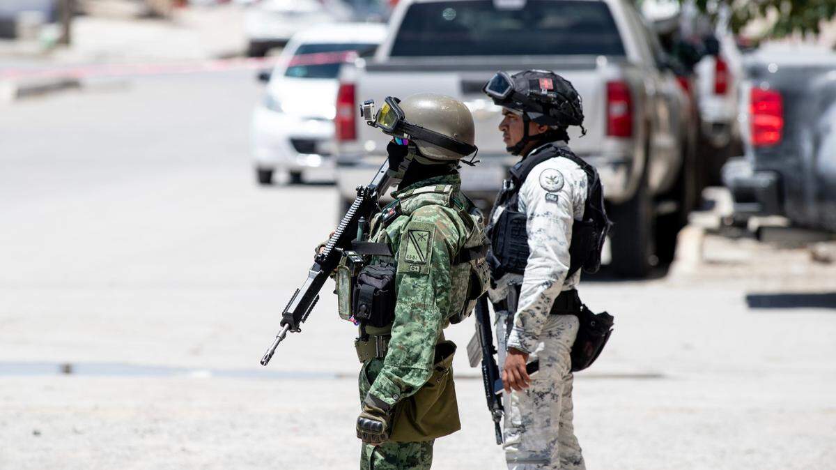 Foto de archivo de un soldado y un guardia mexicano vigilando el lugar donde ocurrió un homicidio en Juárez, México, en junio de 2024.