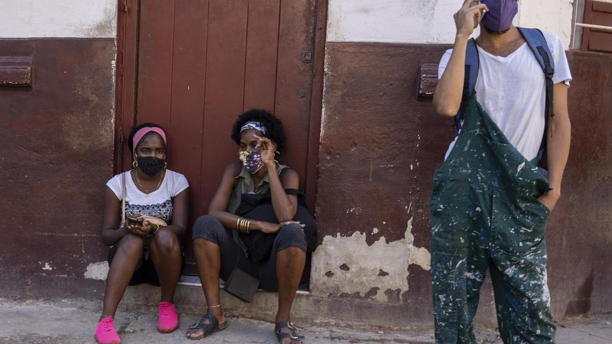 Las personas usan máscaras durante la pandemia de COVID-19 afuera de una tienda de comestibles donde esperan que abra en La Habana, Cuba, el martes 12 de octubre de 2021. (AP Foto/Ramón Espinosa)