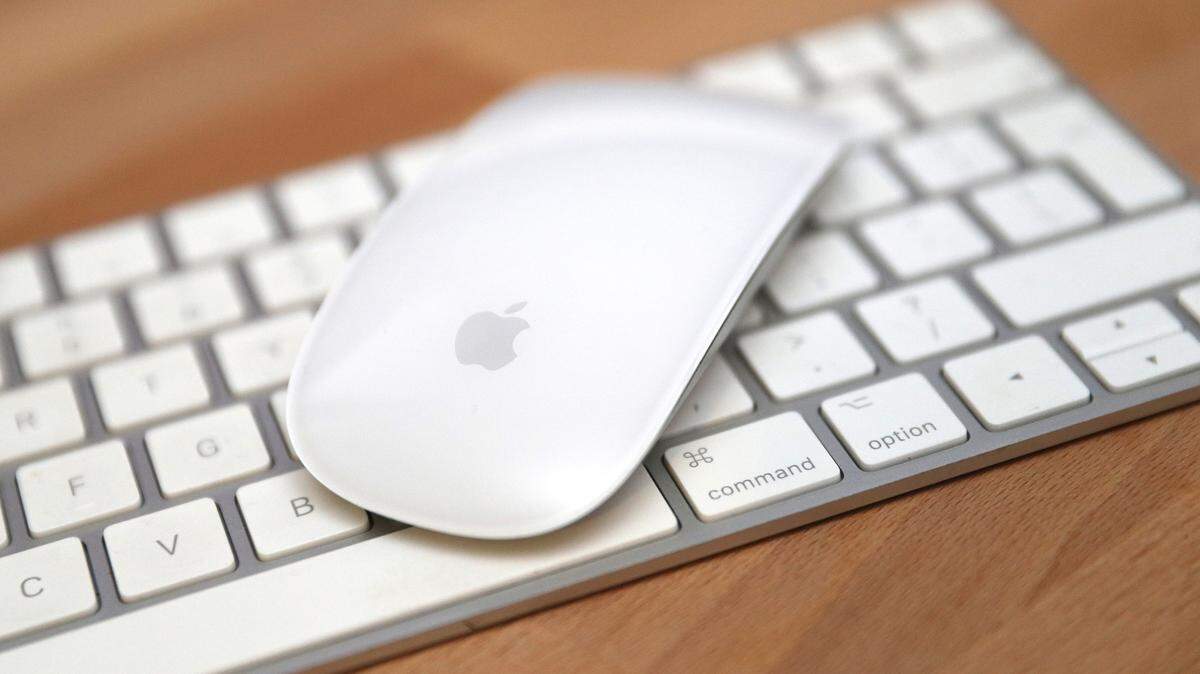 Vista general de un mouse con la marca Apple sobre un teclado Apple. 