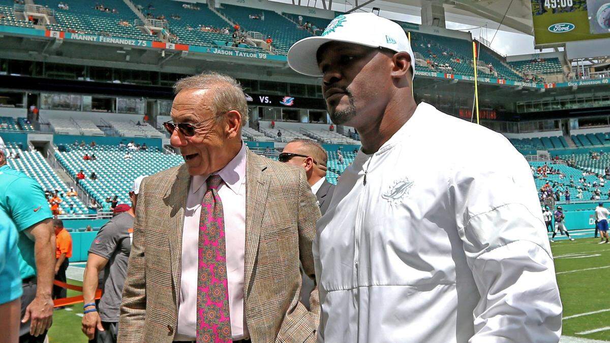 El dueño de los Dolphins Stephen M. Ross (izq.) y el exentrenador Brian Flores hablan antes de un partido ante los Ravens de Baltimore, el 8 de septiembre de 2019 en el Hard Rock Stadium de Miami Gardens.