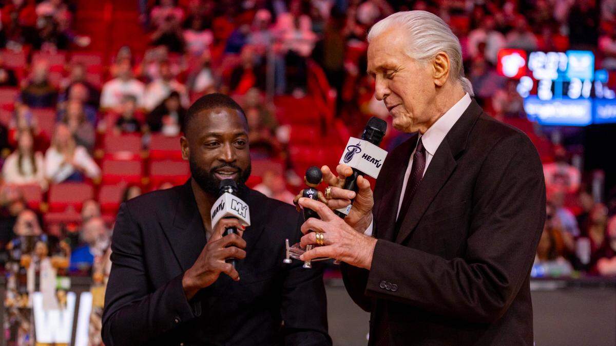 Dwyane Wade y el presidente del Heat Pat Riley conversan en el homenaje que le brindó el equipo al legendario jugador por ser exaltado al Salón de la Fama del Basquetbol, el 14 de enero de 2024 en Miami.