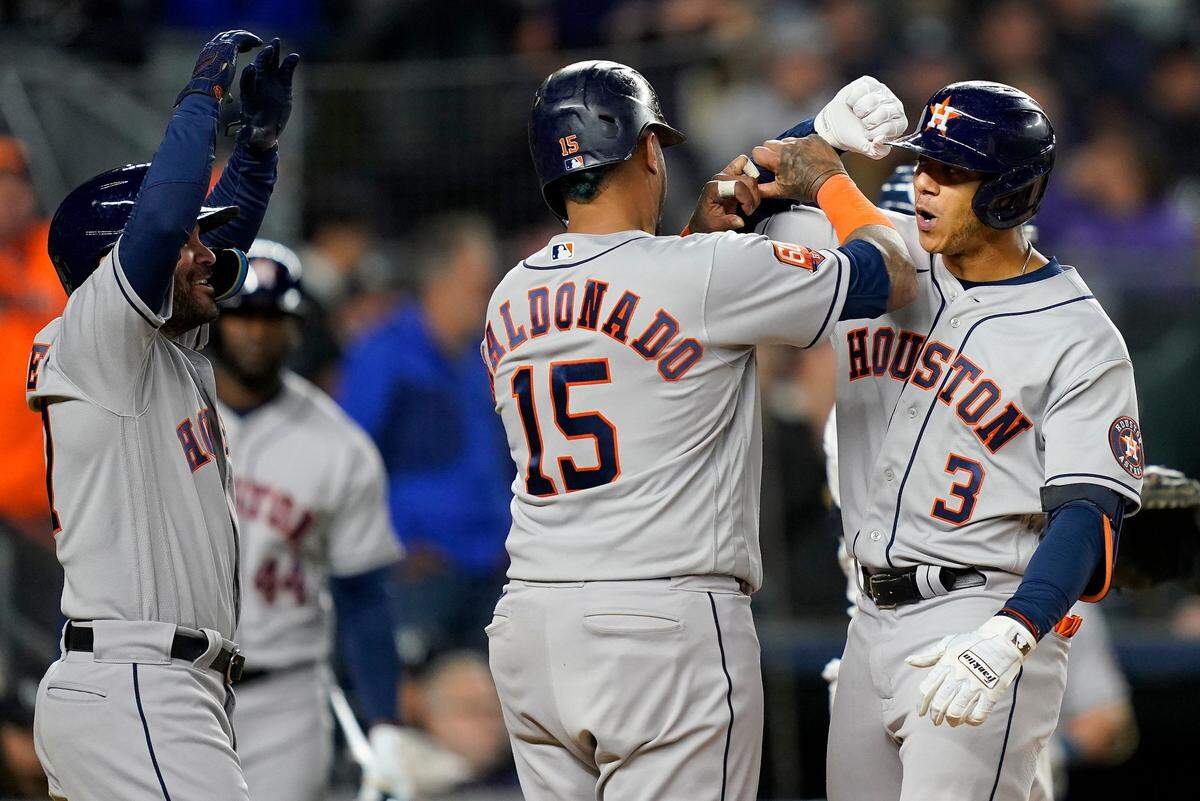 El torpedero de los Astros Jeremy Peña (der.) celebra con José Altuve (izq.) y Martin Maldonado tras conectar un jonrón en el tercer inning del partido ante los Yankees, en el cuarto juego de la Serie de Campeonato de la Liga Americana, celebrado el 23 de octubre de 2022 en Nueva York.