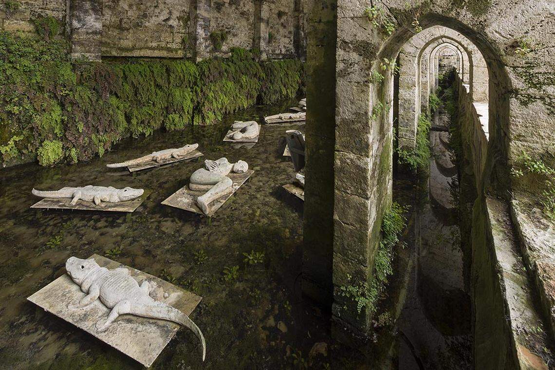 La experiencia se vuelve immersiva en la fuente medieval Fonte delle Fate con ‘I Dormienti’ de Mimmo Paladino: figuras en posición fetal que parecen flotar o dormir en el agua acompañadas de cocodrilos, creando una burbuja sonora y visual que traslada al espectador.