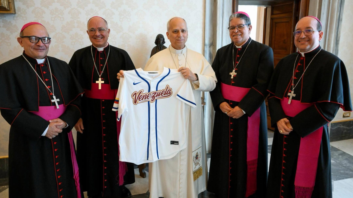 El papa León XIV sostiene la camiseta de la selección venezolana de béisbol tras recibirla en una audiencia en el Vaticano.