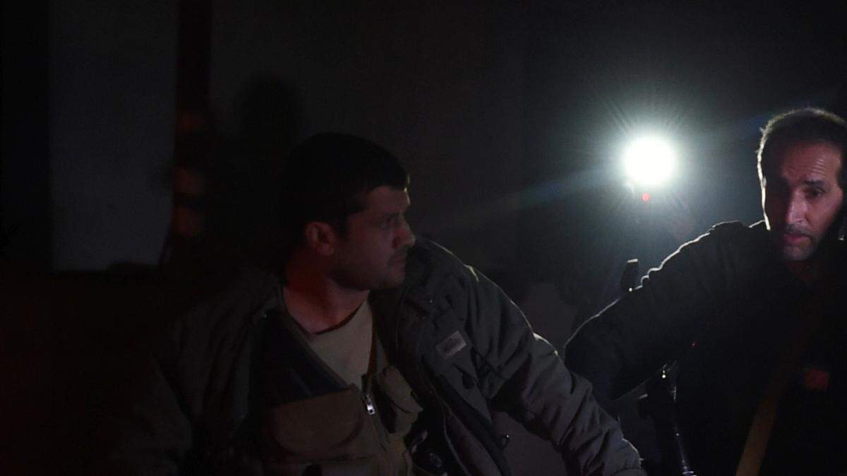 Vigilantes de seguridad trasladan a un hombre herido en un ataque contra la embajada de España en Kabul, Afganistán, el viernes 11 de diciembre. 