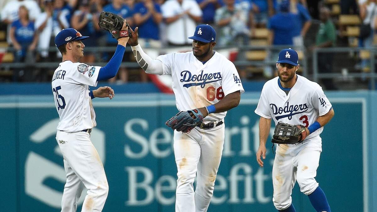 Los jugadores de los Dodgers Cody Bellinger, Yasiel Puig y Chris Taylor (de izq. a der.) celebran tras ganar ante los Cerveceros, en el quinto partido de la Serie de Campeonato de la Liga Nacional, el 17 de octubre de 2018.