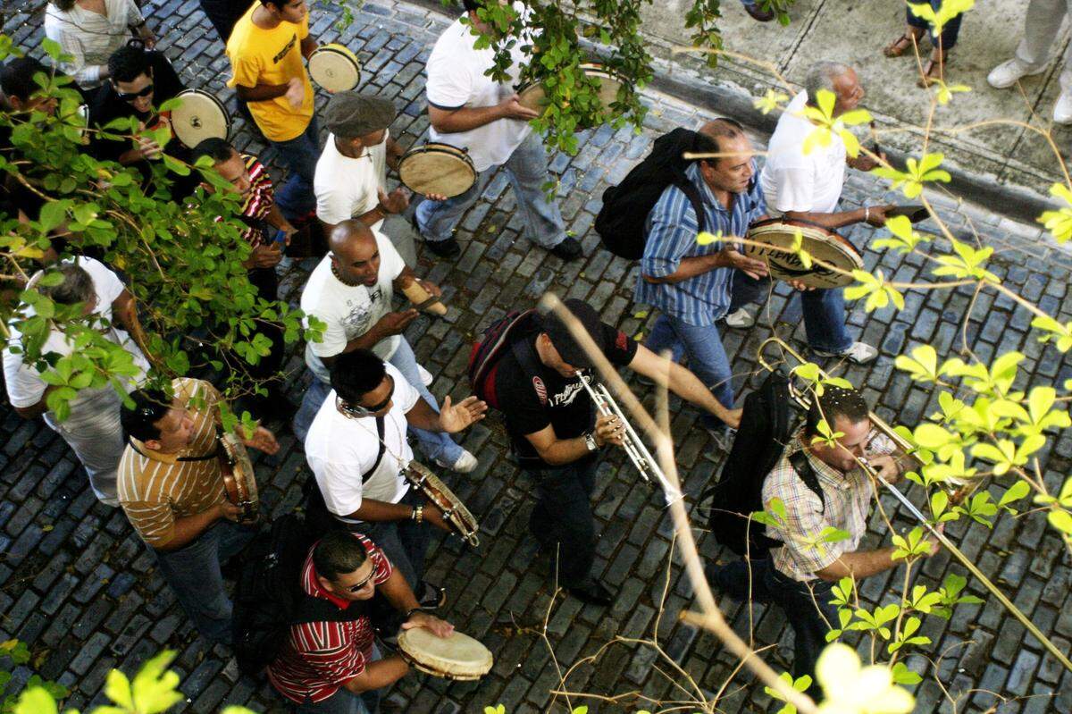 Pleneros caminan por las calles adoquinadas del Viejo San Juan entonando canciones típicas de Navidad.