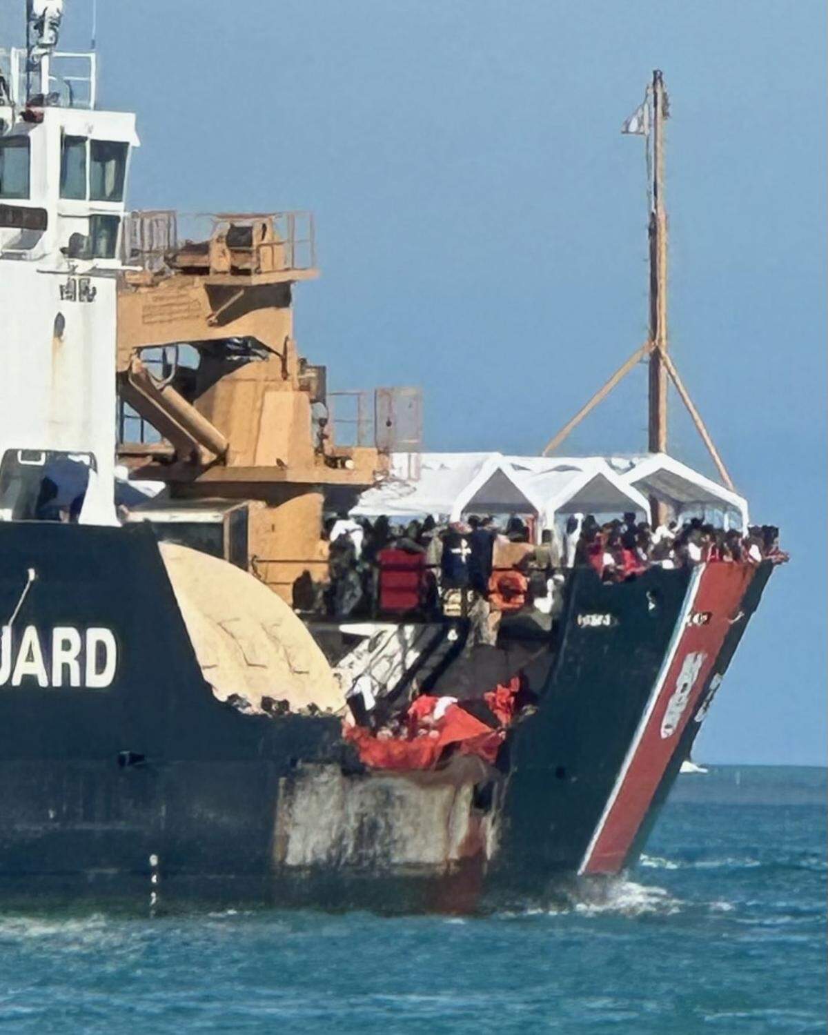Cientos de inmigrantes cubanos se alinean en la cubierta de un barco de la Guardia Costera de EEUU cuando se acerca a Cayo Hueso, Florida, el jueves 5 de enero de 2022.