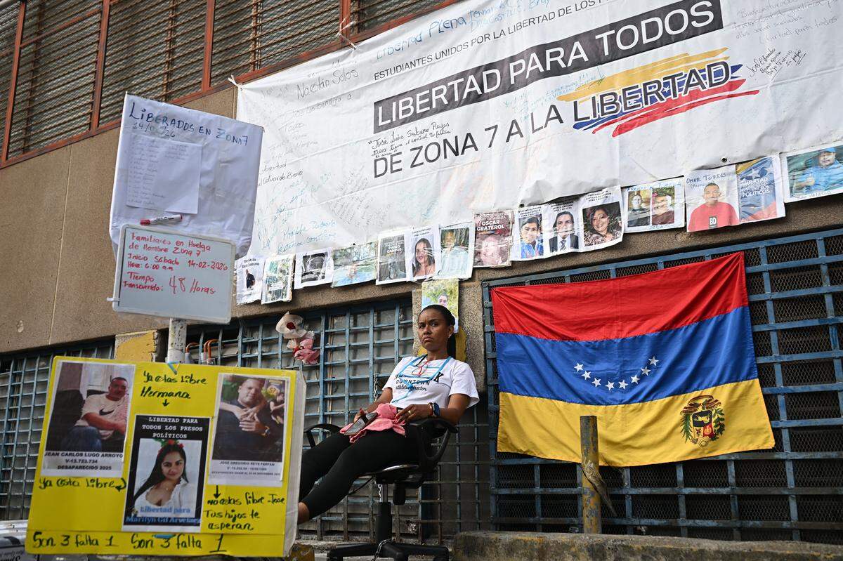 Un familiar de un preso político se sienta en una silla durante una huelga de hambre a las afueras de la cárcel Zona 7 de la Bolivarian National Police (PNB) en Caracas el 16 de febrero de 2026.