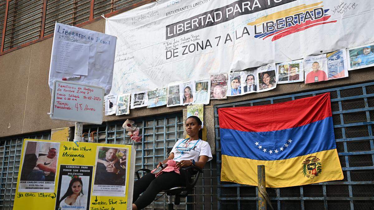 Un familiar de un preso político se sienta en una silla durante una huelga de hambre a las afueras de la cárcel Zona 7 de la Bolivarian National Police (PNB) en Caracas el 16 de febrero de 2026.