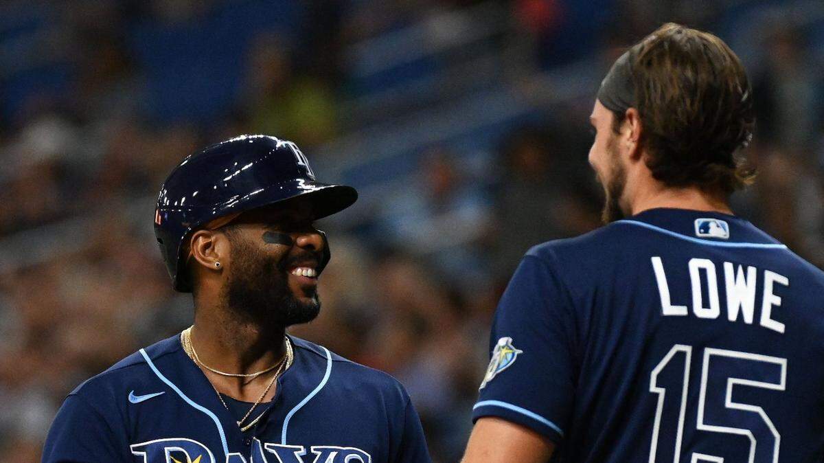 El jugador de los Rays de Tampa Bay Josh Lowe (izq..) recibe el saludo del cubano Yandy Díaz tras anotar una carrera en el segundo inning del partido ante los Medias Rojas de Boston, celebrado el 11 de abril de 2023.