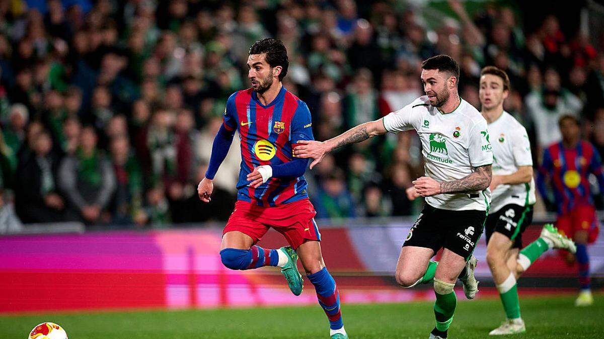 El jugador de Barcelona Ferrán Torres avanza con el balón ante la marca de Manu Hernando, del Racing de Santander, en el  partido de octavos de final de la Copa del Rey celebrado el 15 de enero de 2026 en Santander, España. 