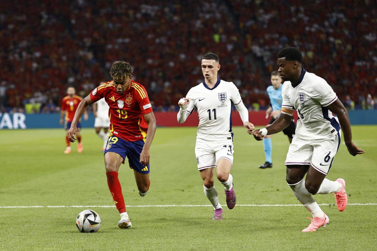 El jugador de España Lamine Yamal (izq.) conduce el balón ante la marca de Phil Foden (centro) y Marc Guehi, en el partido final de la Eurocopa celebrado el 14 de julio de 2024 en Munich, Alemania.