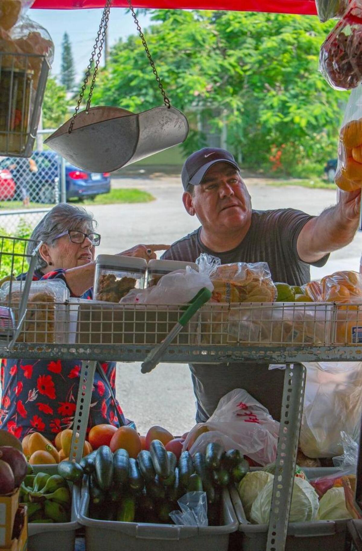 Tamayo ayuda a una cliente a escoger frutas el 20 de junio del 2018 en Miami.