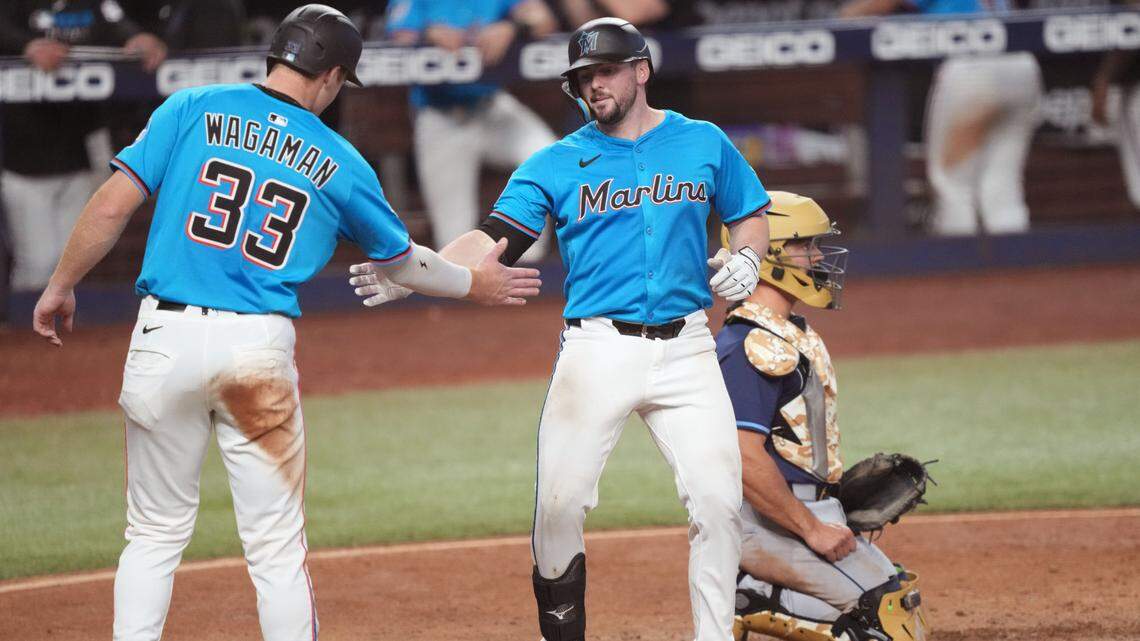 May 18, 2025; Miami, Florida, USA; Miami Marlins catcher Liam Hicks, right, is congratulated by left fielder Eric Wagaman (33) after his two-run home run in the sixth inning against the Tampa Bay Rays at loanDepot Park. Mandatory Credit: Jim Rassol-Imagn Images