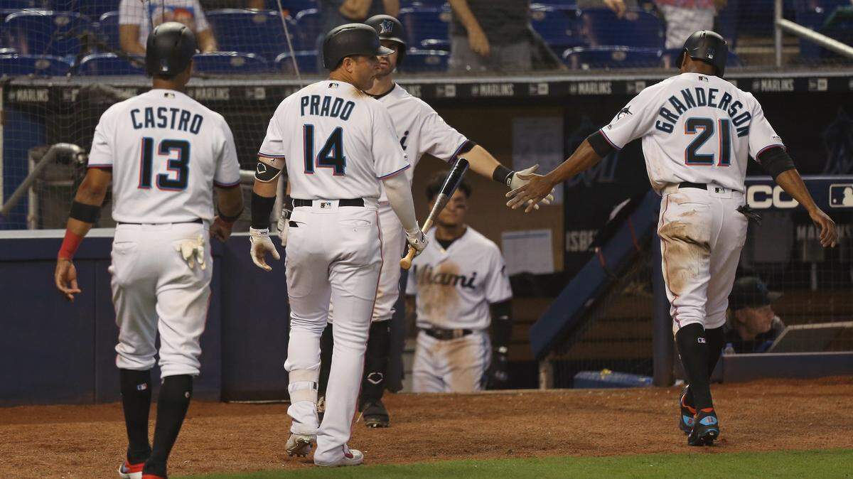 MARTIN PRADO (14) y Starlin Castro (13) felicitan a Curtis Granderson (21) tras anotar con un doble de Lewis Brinson (9) en juego contra los Dodgers el 15 de agosto.