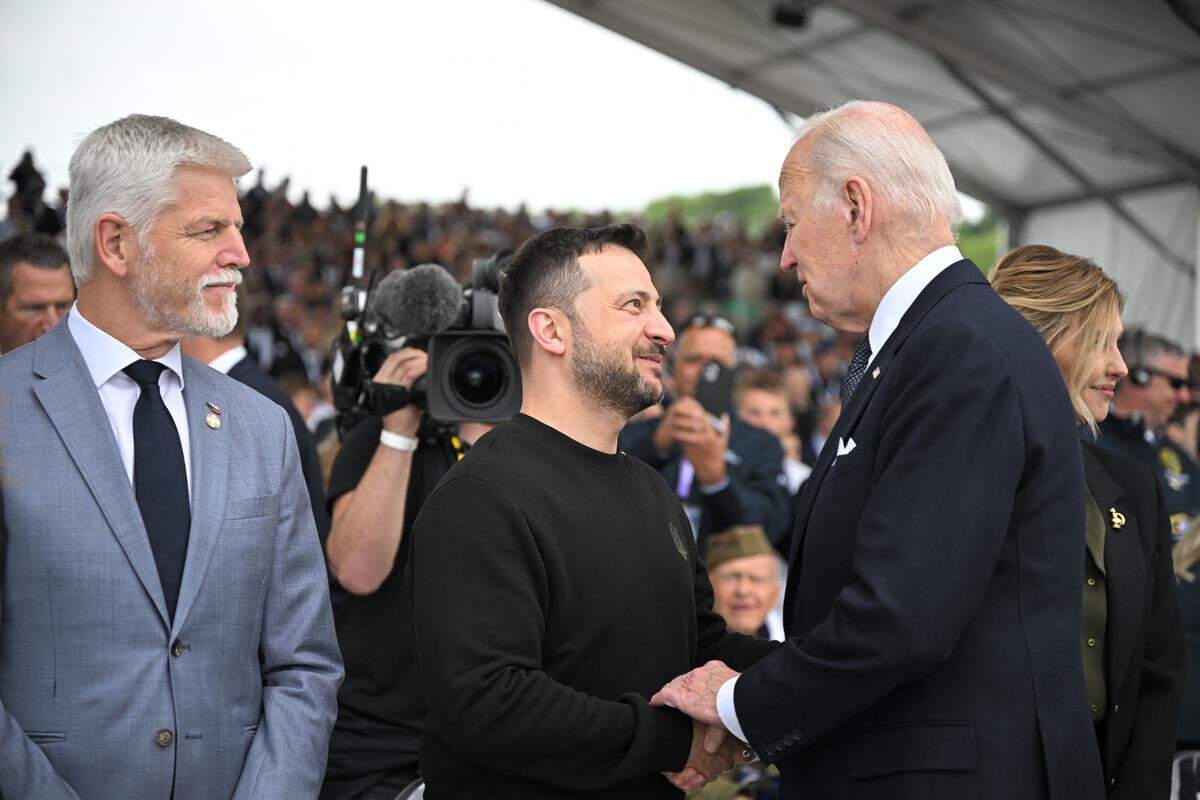 El presidente Joe Biden saluda al presidente ucraniano, Volodimir Zelenski, y su esposa, Olena Zelenska, el jueves en Omaha Beach, Francia.