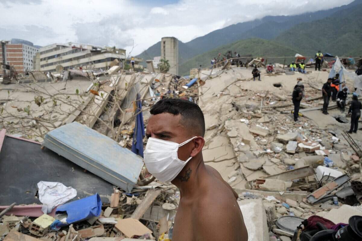 A volunteer looks on during the search for victims in the rubble of collapsed buildings in Caraballeda, La Guaira State, Venezuela on June 28, 2026, following the June 24 twin earthquakes. (Photo by Mauricio VALENZUELA / AFP via Getty Images)