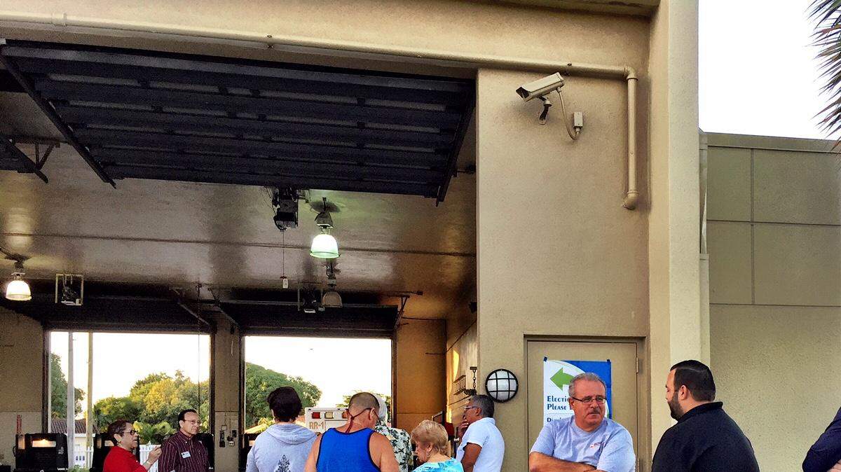 Un grupo de personas espera que se abran las puertas de un centro de votación en Hialeah.